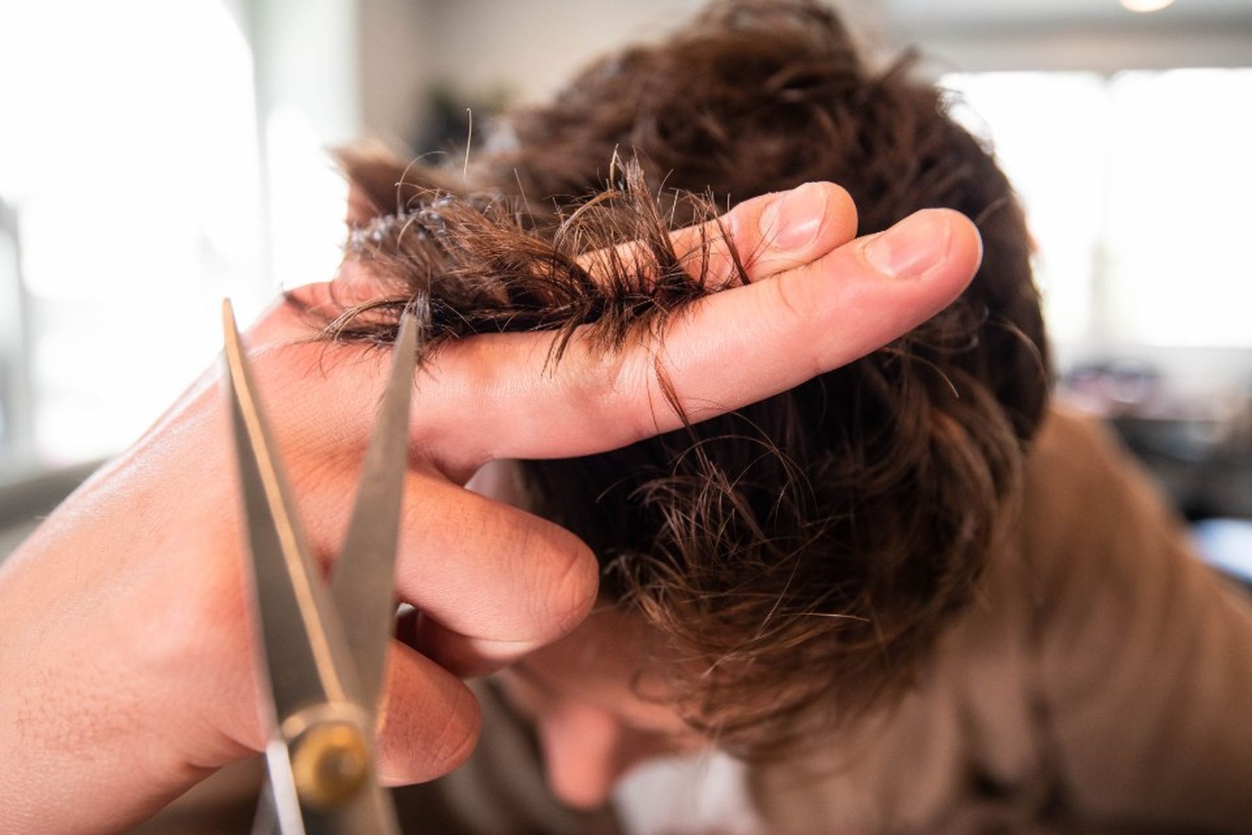 Friseurin schneidet Haare mit der Schere